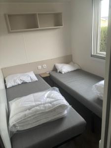 Ένα ή περισσότερα κρεβάτια σε δωμάτιο στο Mobil home climatisé 8 couchages 3 CHAMBRES 222 SIBLU LES CHARMETTES