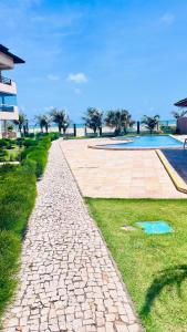 a cobblestone walkway next to a swimming pool at Todo Azul do Mar in Taíba