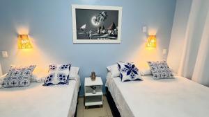 two twin beds in a room with two lamps at Todo Azul do Mar in Taíba