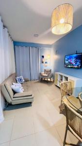 a living room with a couch and a tv at Todo Azul do Mar in Taíba