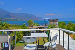 a balcony with a table and chairs and the ocean at Mundo Abu San Juan La laguna in San Juan La Laguna