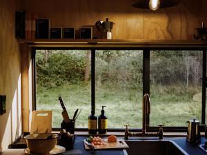 a kitchen window with a view of a field at Off-Grid Cabin Deep in Nature - Pet Friendly - Barney in Dingadee