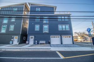 Un edificio azul con puertas blancas y un banco al frente. en Brand New Beach house with roof top near bay and beach, en Seaside Heights
