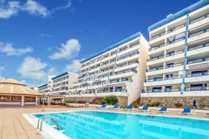 a large apartment building with a swimming pool at Modern Designer Apartment Taurito in Taurito