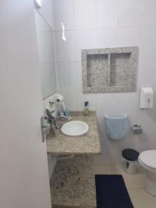 a bathroom with a sink and a toilet at Beach House 2 in Guarujá