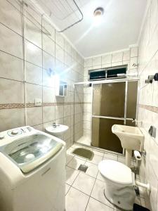 サントスにあるApartamento em Santos no Boqueirãoのトイレと洗面台を備えた白いバスルーム