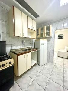 サントスにあるApartamento em Santos no Boqueirãoの白いキャビネットと白い冷蔵庫のあるキッチン