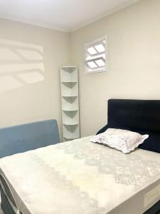 サントスにあるApartamento em Santos no Boqueirãoの枕が置かれたベッドのある寝室 +4枚の写真