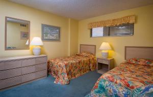 a hotel room with two beds and a mirror at Atalaya Towers by Capital Vacations in Myrtle Beach