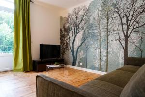 a living room with a couch and a tv at Gîte Roche Pointue - Ski - Domaine in Villard-de-Lans