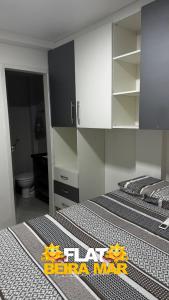 two twin beds in a room with a bathroom at Flat Beira mar in Cabo de Santo Agostinho +8 photos