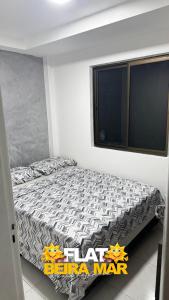 a bedroom with a bed in a room with a window at Flat Beira mar in Cabo de Santo Agostinho