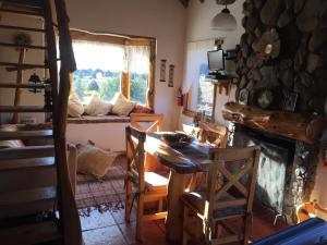 a living room with a table and a fireplace at Cabanas Peumahue in Villa Meliquina