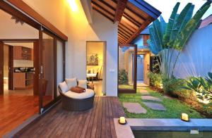 a living room with a couch on a wooden deck at Desa Di Bali Villas in Kerobokan