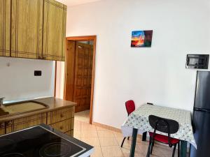 a kitchen with a small table and a refrigerator at Villa BASHLLARI A&B appartamenti di fronte al mare in Vlorë