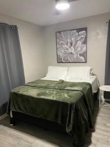 a bedroom with a bed with a green blanket on it at City and Stadium Sanctuary Vibes in Orlando