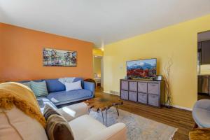 sala de estar con sofá azul y paredes amarillas en Colors of Colorado Parks & Trails Dog-Friendly, en Fountain