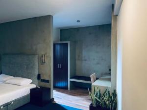 a small bedroom with a bed and a table at Hidden Negombo By Sana's in Negombo