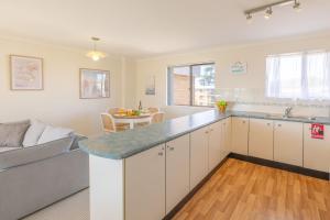 a kitchen and living room with a couch and a table at Intrepid 12 right on the beachfront in Shoal Bay +13 photos