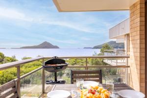 a grill on a balcony with a view of the ocean at Intrepid 12 right on the beachfront in Shoal Bay