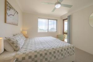 a bedroom with a bed and a ceiling fan at Intrepid 12 right on the beachfront in Shoal Bay