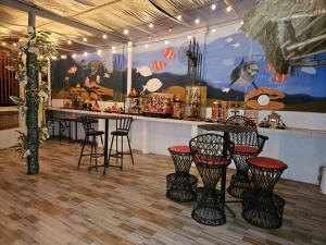 a bar with chairs and a table in a room at wombats beach resort, bar and restaurant in Olongapo
