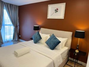 a bedroom with a large white bed with blue pillows at The Atrium at Jalan Ampang by OKBnB - Classy 3Bedroom Family Suite nearby KLCC , TRX and Pavilion KL in Kuala Lumpur +21 photos