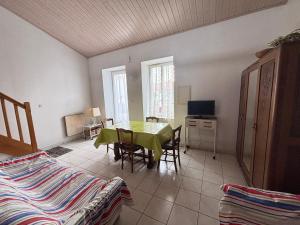 un salon avec une table et une télévision dans l'établissement Maison au bourg de Saint-Mathurin, proche commerces, à 10km des plages des Sables d'Olonne, pour 2 pers. - FR-1-197-546, à Saint-Mathurin