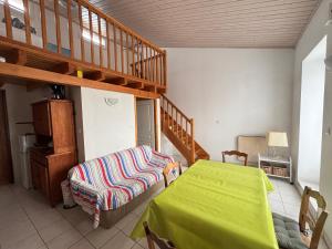 - un salon avec un lit et un escalier dans l'établissement Maison au bourg de Saint-Mathurin, proche commerces, à 10km des plages des Sables d'Olonne, pour 2 pers. - FR-1-197-546, à Saint-Mathurin