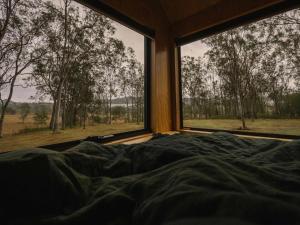 una cama en una habitación con una ventana grande en Secluded & Pet Friendly Cabin Deep in Nature - Remy, en Coleyville