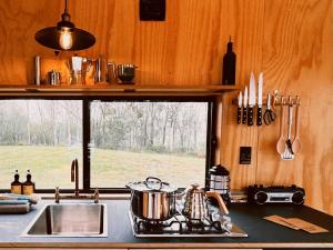 Una cocina con estufa, fregadero y ventana. en Secluded & Pet Friendly Cabin Deep in Nature - Remy, en Coleyville 13 fotos más