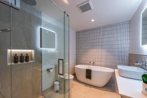 a bathroom with a shower and a tub and a sink at Vista Ridge - Northlake in Wanaka +27 photos
