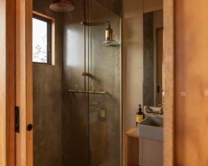 un baño con ducha y lavabo en Secluded & Pet Friendly Cabin Deep in Nature - Remy, en Coleyville