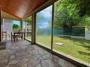 a screened in porch with a table and chairs at Maison spacieuse 6 pers. près plage avec jardin - FR-1-476-204 in La Faute-sur-Mer