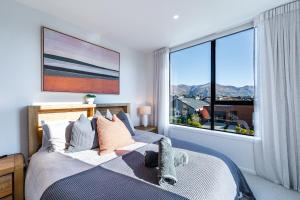 a bedroom with a bed with a large window at Vista Ridge - Northlake in Wanaka