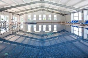 a large swimming pool with blue chairs in the middle at Sunrise Luxurious holiday home in Cubert