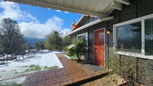 a house with a red door and a brick walkway at Rustic Yosemite Cottage-King Suite-Mountain Views in Oakhurst