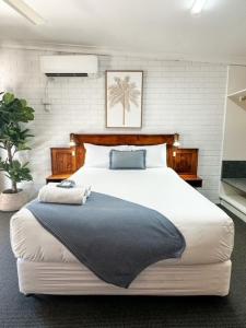 a bedroom with a large bed in a room with a tv at Pacific Sun Bargara in Bargara