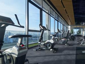 a row of exercise bikes in a gym with windows at The Atrium at Jalan Ampang by OKBnB - Classy 3Bedroom Family Suite nearby KLCC , TRX and Pavilion KL in Kuala Lumpur