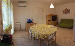 a living room with a table with a yellow table cloth at Lido degli Estensi - condominio Ravenna in Lido degli Estensi
