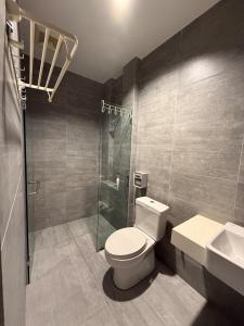a bathroom with a toilet and a shower and a sink at Riverine Diamond Condominium at City Centre in Kuching