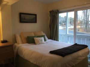 a bed in a bedroom with a large window at The Beach Rose Inn in Wells