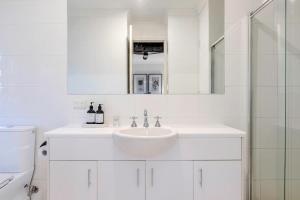 a white bathroom with a sink and a mirror at The Terrace - close to Adelaide Oval Cafes CBD Shopping in North Adelaide +23 photos