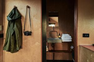 Baño con puerta con lavabo y espejo en Secluded & Pet Friendly Cabin Deep in Nature - Zerya, en Coleyville