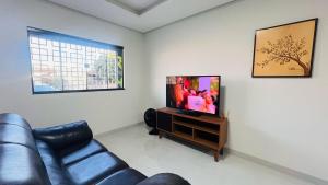 a living room with a couch and a flat screen tv at Ap bem localizado e aconchegante in Sinop