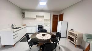 a kitchen with a table and chairs and a refrigerator at Ap bem localizado e aconchegante in Sinop +2 photos