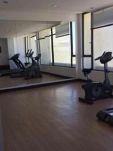 een sportschool met loopbanden en hometrainers in een kamer bij Edificio Concepto in Calama +1 foto