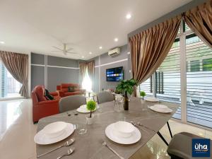 a dining room with a table and a living room at Bandar Dato Onn By UHA in Johor Bahru