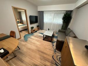 a living room with a couch and a table and a television at The North Garden Hotel Beijing Wangfujing in Beijing