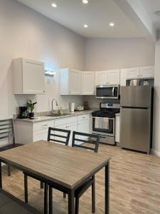 a kitchen with white cabinets and a table and chairs at Modern 1-bedroom Studio with Kitchen and Laundry in Santa Clarita